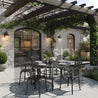 Outdoor patio setting with a dining table and chairs under a pergola.