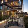 Modern outdoor patio with table and chairs under a decorative canopy at dusk.