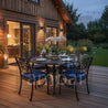 Outdoor dining setup on a wooden deck with a house in the background