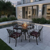 Outdoor patio set with fire pit table and chairs on a modern patio.