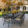 Outdoor patio set with a long dining table and chairs on a patio area.